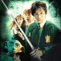 Jedlý obrázek na dort s Harrym Potterem držícím meč, po boku Ron a Hermiona a skřítek Dobby na tmavě zeleném pozadí.