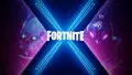 Jedlý obrázek na dort s modrým neonovým písmenem X, lebkou a kočičí maskou na tmavém pozadí s logem Fortnite
