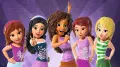 Pět postaviček LEGO Friends v letních topech na fialovém pozadí, uprostřed zpěvačka s mikrofonem, jedlý obrázek na dort