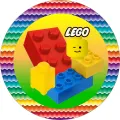 Kulatý jedlý obrázek s barevnými kostkami LEGO, žlutou hlavou panáčka a duhovým lemem na žlutozeleném pozadí, na dort