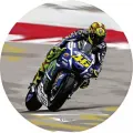 Závodní motorka modrozelené barvy se žlutým číslem 46 a jezdcem v zatáčce na asfaltovém okruhu, jedlý obrázek na dort