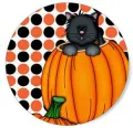 Černá kočka se zelenýma očima vykukuje z oranžové dýně na bílém pozadí s puntíky, jedlý obrázek na dort na Halloween
