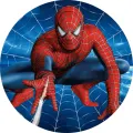 Spiderman v červenomodrém obleku v dřepu při skoku, z ruky vystřeluje pavučinu, v pozadí modrá pavučina – jedlý obrázek na dort