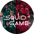 Kulatý jedlý obrázek Squid Game: zelení hráči v teplácích a růžoví strážci v maskách, uprostřed nápis Squid Game, jedlý obrázek na dort