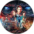 Kulatý jedlý obrázek na dort se skupinou postav ze Stranger Things, modrýma zářícíma očima monstra nad domem a černým pozadím