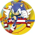 Modrý ježek Sonic běží se zaťatou pěstí mezi zlatými kroužky na žlutém pozadí, jedlý obrázek na dort