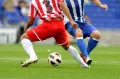 Dva fotbalisté v červeném a modrém dresu bojují o míč na zeleném trávníku, jedlý obrázek na dort
