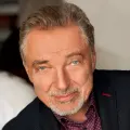 Portrét Karla Gotta v tmavém saku se šedinami na decentním pozadí, jedlý obrázek na dort