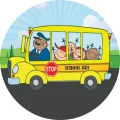 Kulatý jedlý obrázek na dort se žlutým školním autobusem, usměvavým řidičem a dětmi v oknech na modrém nebi a zelené louce