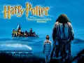 Harry Potter stojí vedle Hagrida před osvětleným hradem Bradavice v noci, s parním vlakem na mostě a jedlý obrázek na dort