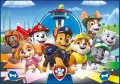 Pejsci z Paw Patrol v čele s Chasem a Marshallem běží před modrou věží, zelenými kopci a mostem, jedlý obrázek na dort