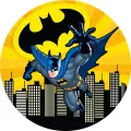 Kulatý jedlý obrázek na dort: Batman v tmavě modrém plášti letí nad městem na žlutém pozadí s černým symbolem netopýra