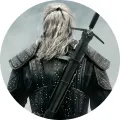 Geralt z Rivie od zad v šedé mlze, s bílými vlasy, koženou zbrojí a mečem na zádech, jedlý obrázek na dort