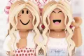 Dvě blonďaté postavičky z hry Roblox v pastelově růžových šatech s mašlemi ve vlasech, jedlý obrázek na dort