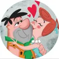 Kulatý jedlý obrázek na dort: Fred a Wilma Flintstoneovi objímající se, nad nimi červená srdíčka na šedém pozadí