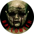Temná porcelánová panenka s prasklou tváří, prázdnými černými očima a krví, pod ní červený nápis Halloween, jedlý obrázek na dort