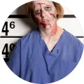 Zombie žena v modrém vězeňském oděvu s ranami a krví stojí před policejní výškovou tabulí, jedlý obrázek na dort
