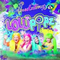 Členky skupiny Lollipopz v barevných parukách pod fialovo-modrým nápisem na pozadí s barevnými cákanci, jedlý obrázek na dort