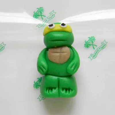 Jedlá figurka želvy Ninja Michelangelo z kokosové hmoty o velikosti 5 cm na zdobení dortů